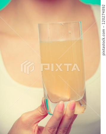 Woman holding glass with water and effervescent tablet Woman holding glass with water and effervescent tablet 120274892