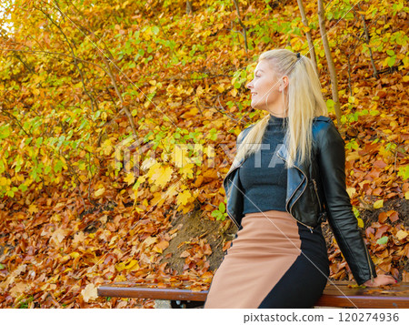 Fashion woman relaxing in autumn park Fashion woman relaxing in autumn park 120274936