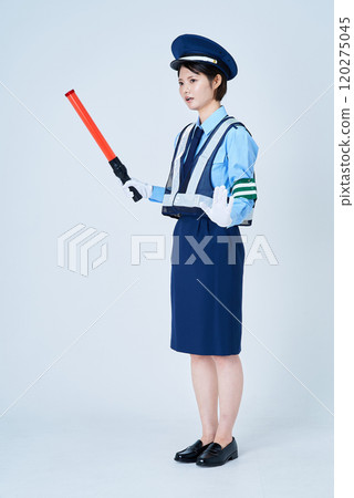 A woman wearing a security guard uniform and holding a red stick A woman wearing a security guard uniform and holding a red stick 120275045