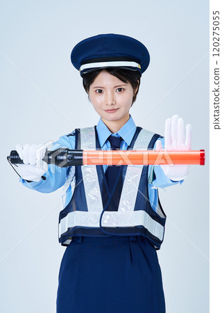 A woman wearing a security guard uniform and holding a red stick A woman wearing a security guard uniform and holding a red stick 120275055
