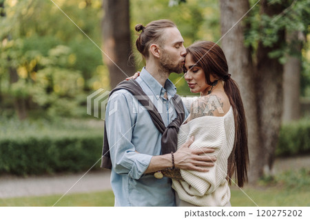 Love, hug and happy with couple in park for romance, bonding and summer vacation. Loving young couple hugging and smiling together on nature background. Beautiful girl with tattooed body outdoor. 120275202