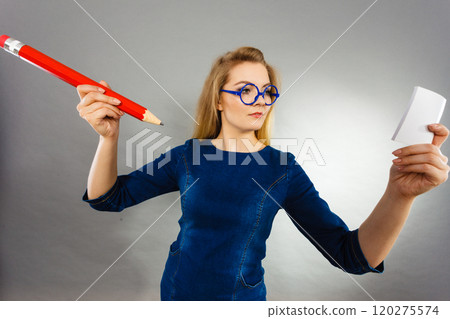 Serious woman holds big pencil note paper in hand 120275574