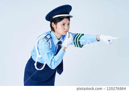 A female security guard blowing a whistle and pointing 120276864