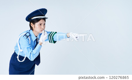 A female security guard blowing a whistle and pointing A female security guard blowing a whistle and pointing 120276865