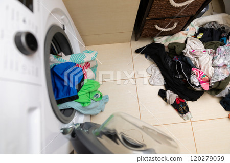Laundry Day Using a Washing Machine Filled with Colorful Clothes All Around Me 120279059