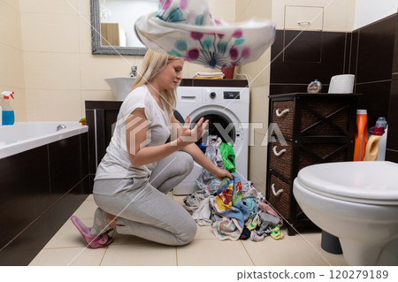 Frantic Laundry Day Struggling with a Large Pile of Clothes That Needs Attention and Care 120279189