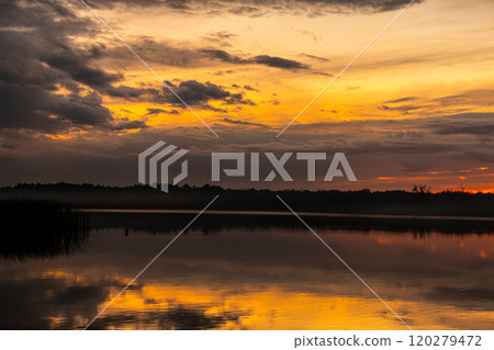 The Stunning Sunset Beautifully Reflected on the Tranquil Surface of the Peaceful Lake 120279472