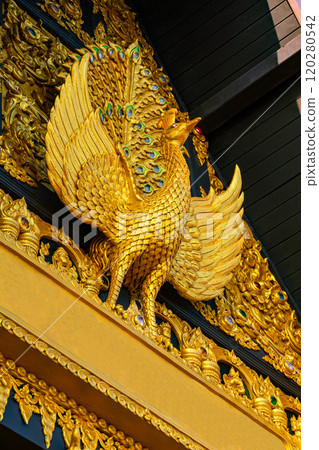 Golden sculpture of Peacock at the facade of main hall in buddhist temple. 120280542