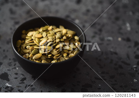 pumpkin seeds in black bowl on terrazzo countertop pumpkin seeds in black bowl on terrazzo countertop 120281143