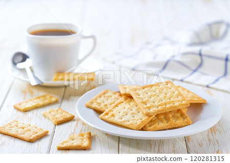 Tasty wheat water crackers and coffee on a light kitchen table, selective focus. 120281315