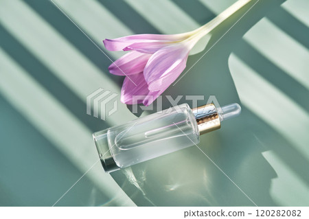 Bottle of cosmetic serum with pipette on green background with shadow stripes. 120282082