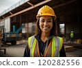 Portrait of African American happy smiling young woman in vest and protective yellow helmet working in warehouse. Ai generation. Concept of industry and equality 120282556