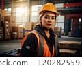 Portrait of pretty young woman in vest and protective hardhat on background of warehouse with boxes. Generative Ai. Concept of manufacturing industry and equality 120282559