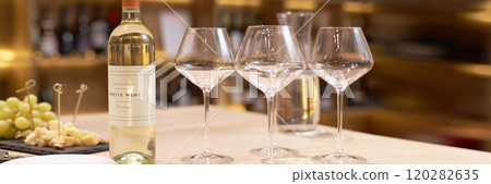 Website banner of served table with polished and clean crystal glasses, bottle of expensive wine and snacks 120282635