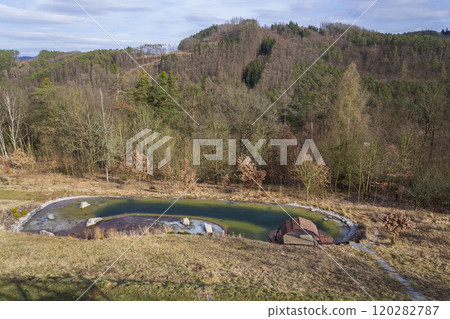Ice on natural swimming pool filtering water without chemicals, sunny freezing day 120282787