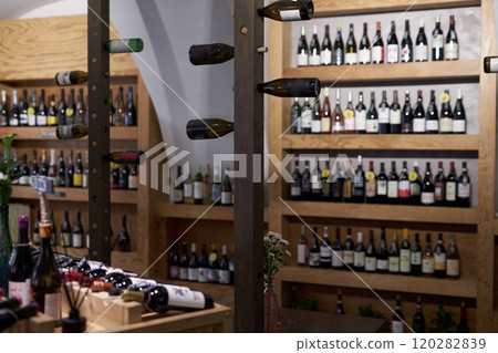 Huge vertical wine racks with different types of wine in center of wine cellar with wooden cabins to store wine Huge vertical wine racks with different types of wine in center of wine cellar with wooden cabins to store wine 120282839