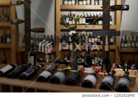 Wine cellar fully equipped with wooden furniture and bottles of red and white wine 120282840