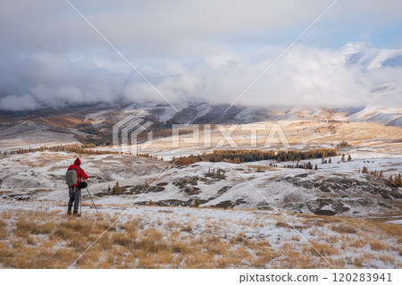 Hiker explores snowy Altai Mountains in stunning winter landscape Hiker explores snowy Altai Mountains in stunning winter landscape 120283941