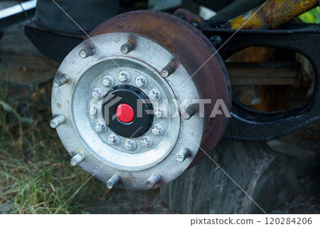 Rusty wheel hub showcasing intricate design details on an abandoned vehicle 120284206