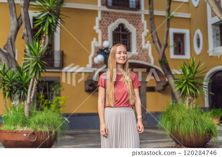 Female tourist walking through the colorful colonial streets of Puebla, Mexico. Travel, cultural exploration, and vibrant architecture concept Female tourist walking through the colorful colonial streets of Puebla, Mexico. Travel, cultural exploration, and vibrant architecture concept 120284746
