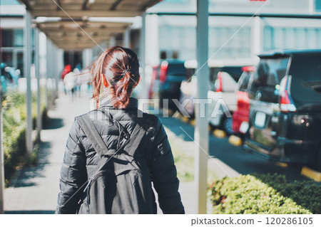 一名婦女沿著停車場走道行走的後視圖 120286105