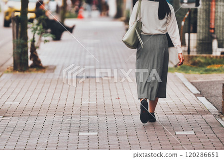 Back view of a woman walking in the city 120286651