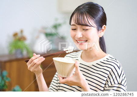 Young woman eating rice Young woman eating rice 120286745