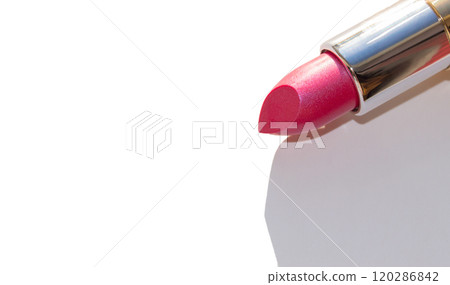 Close-up of a part of a gold lipstick tube on a white background with a copy of the space on the left 120286842