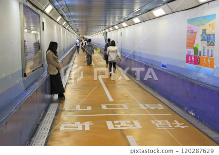 People walking along the undersea Kanmon Tunnel pedestrian path and the prefectural border People walking along the undersea Kanmon Tunnel pedestrian path and the prefectural border 120287629