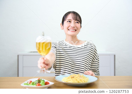 Young woman drinking beer 120287753