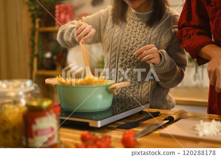 Young married beautiful couple in sweaters preparing dinner on Christmas Day in kitchen 120288178