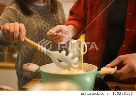 Cropped shot of young couple preparing dinner on Christmas Day in kitchen 120288198