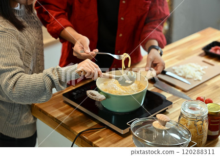 Young married couple making pasta together during the festive season Young married couple making pasta together during the festive season 120288311