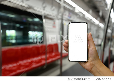 Hand holding smartphone with white blank screen inside a subway train 120288567