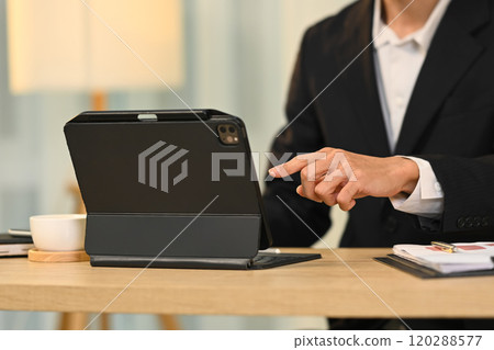 Cropped shot businessman in formalwear managing tasks on digital tablet 120288577