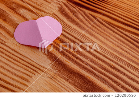 Pink heart cut out of paper on a wooden light background 120290550