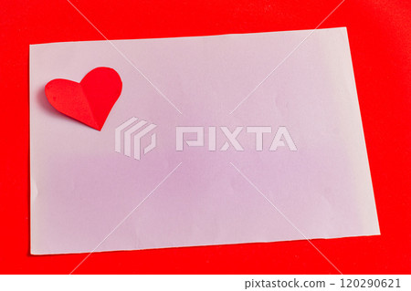 A love note with a paper heart on a purple leaf on a bright red background A love note with a paper heart on a purple leaf on a bright red background 120290621