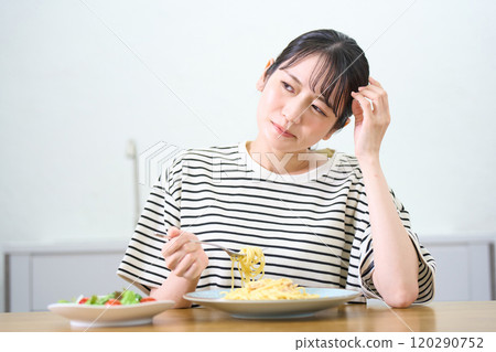 年輕女子吃麵食，食慾不振，擔憂 120290752