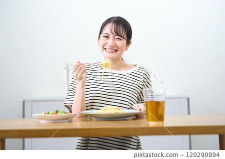 A young woman eating pasta A young woman eating pasta 120290894