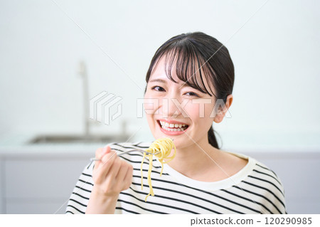 A young woman eating pasta A young woman eating pasta 120290985