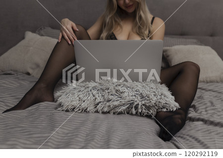 A beautiful, young girl shoots a webcam, works as a model. The concept of online flirting, sex on the Internet A beautiful, young girl shoots a webcam, works as a model. The concept of online flirting, sex on the Internet 120292119