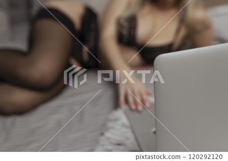 A beautiful, young girl shoots a webcam, works as a model. The concept of online flirting, sex on the Internet A beautiful, young girl shoots a webcam, works as a model. The concept of online flirting, sex on the Internet 120292120