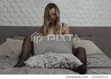 A beautiful, young girl shoots a webcam, works as a model. The concept of online flirting, sex on the Internet A beautiful, young girl shoots a webcam, works as a model. The concept of online flirting, sex on the Internet 120292121