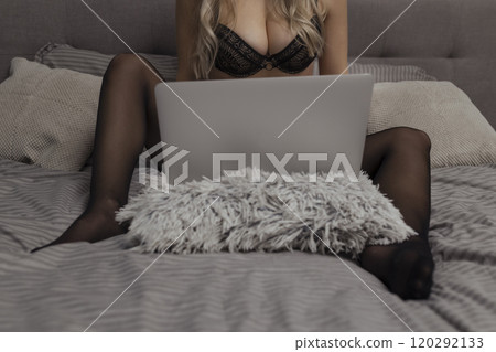 A beautiful, young girl shoots a webcam, works as a model. The concept of online flirting, sex on the Internet A beautiful, young girl shoots a webcam, works as a model. The concept of online flirting, sex on the Internet 120292133