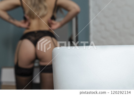 A beautiful, young girl a webcam, works as a model. He takes off his bra. The concept of online flirting, sex on the Internet A beautiful, young girl a webcam, works as a model. He takes off his bra. The concept of online flirting, sex on the Internet 120292134