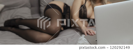 A beautiful, young girl shoots a webcam, works as a model. The concept of online flirting, sex on the Internet A beautiful, young girl shoots a webcam, works as a model. The concept of online flirting, sex on the Internet 120292149