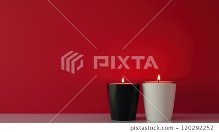 Two candles in black and white are lit on a red background. 120292252
