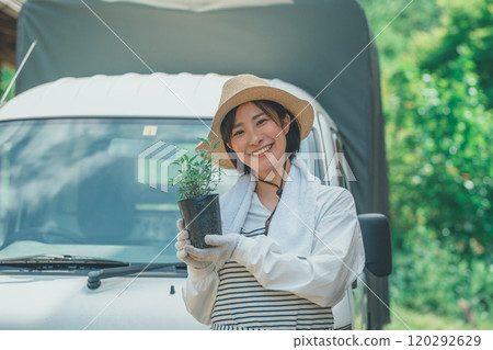 A female flower farmer holding flower seedlings A female flower farmer holding flower seedlings 120292629