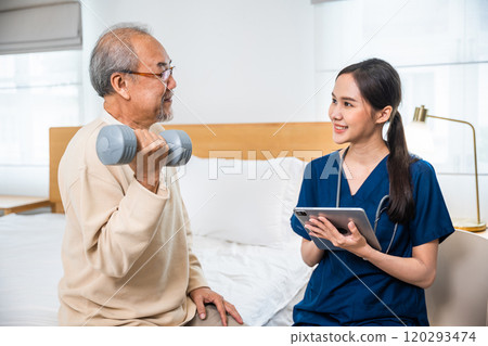 Doctor physiotherapist helping old man in lift dumbbell when nurse taking notes in medical card clipboard at home, Asia nurse support elderly retirement use dumbbell workout exercise physical recovery 120293474
