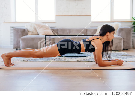 Woman doing plank exercise at home working out Woman doing plank exercise at home working out 120293497